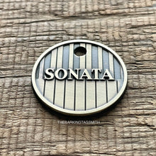 Load image into Gallery viewer, Personalised piano keys dog ID tag deeply engraved into brushed nickel silver metal with raised Sonata name and vertical keyboard pattern on rustic wood background