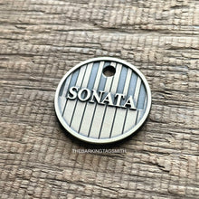 Load image into Gallery viewer, Personalised piano keys dog ID tag deeply engraved into brushed nickel silver metal with raised Sonata name and vertical keyboard pattern on rustic wood background