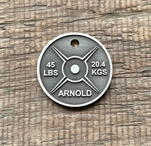 Load image into Gallery viewer, Dog ID tag shaped like a gym weight plate with barbell style design deep engraved on metal tag, personalised engraved pet tag with the name Arnold.