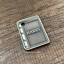 Load image into Gallery viewer, Dog ID tag shaped like a book with the name Harry deep engraved, personalised engraved metal pet tag for book lovers with a classic storybook design.