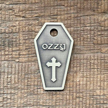 Load image into Gallery viewer, Dog ID tag shaped like a coffin with cross design deep engraved on metal tag, personalised engraved gothic pet tag with the name Ozzy.