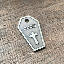 Load image into Gallery viewer, Dog ID tag shaped like a coffin with cross design deep engraved on metal tag, personalised engraved gothic pet tag with the name Ozzy.