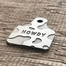 Load image into Gallery viewer, Dog ID tag shaped like a cattle ear tag with cow print pattern and engraved name Garrett, personalised deep engraved metal pet tag.