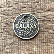 Load image into Gallery viewer, Dog ID tag with swirling galaxy design and engraved name, personalised deep engraved metal pet tag with cosmic space pattern.
