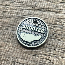 Load image into Gallery viewer, Personalised golf ball dog ID tag with engraved golf ball dimple texture and golf green design in brushed silver metal on rustic wood background