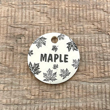 Load image into Gallery viewer, Personalised maple leaf dog ID tag with engraved autumn maple leaf pattern and Maple name in brushed silver metal on rustic wood background