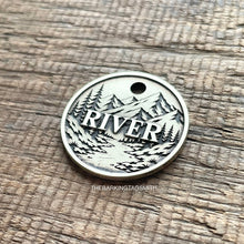 Load image into Gallery viewer, Personalised mountain river dog ID tag with engraved forest, flowing river and mountain landscape in brushed silver metal on rustic wood background