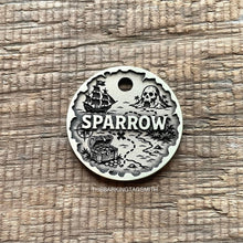 Load image into Gallery viewer, Personalised pirate treasure map dog ID tag with engraved sailing ship, skull island, treasure chest and map trail design in brushed silver metal on rustic wood background