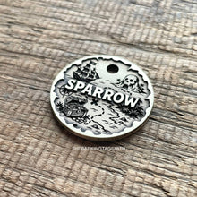 Load image into Gallery viewer, Personalised pirate treasure map dog ID tag with engraved sailing ship, skull island, treasure chest and map trail design in brushed silver metal on rustic wood background