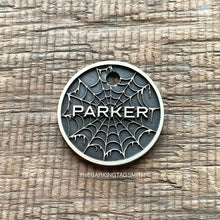 Load image into Gallery viewer, Personalised spider web dog ID tag with engraved gothic web pattern and raised Parker name in brushed silver metal on rustic wood background