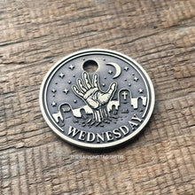 Load image into Gallery viewer, Dog ID tag with zombie hand rising from a graveyard deep engraved on round metal tag, personalised engraved pet tag inspired by Wednesday gothic style.