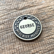 Load image into Gallery viewer, Personalised wizard map dog ID tag with engraved magical footprints and fantasy-inspired lettering in brushed silver metal on rustic wood background